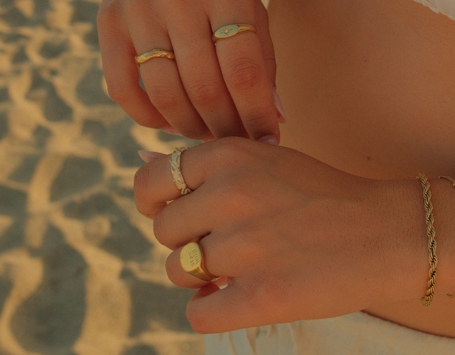 women's hand wearing gold plated waterproof rings